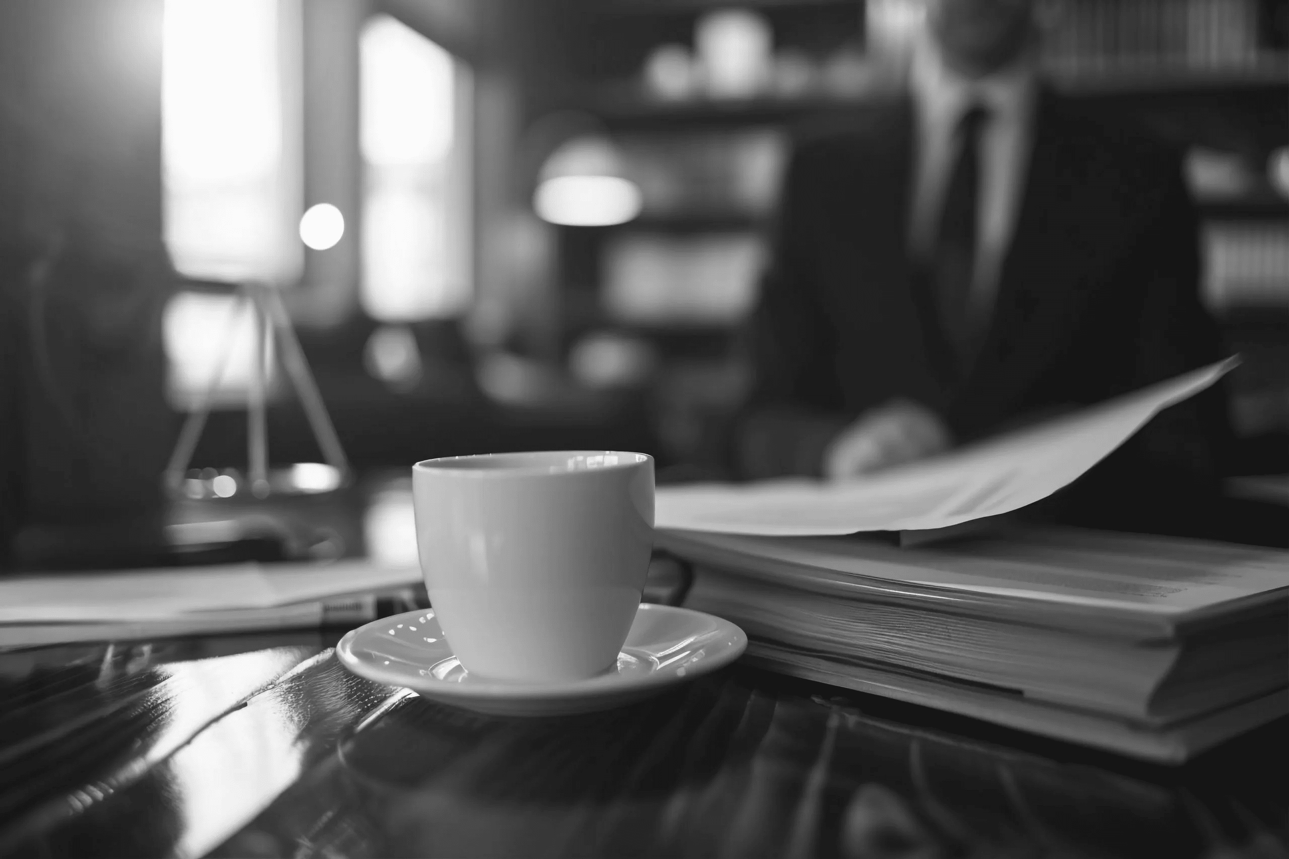 Servizi Legali a Mantova 1 uomo seduto in una caffeteria davanti a contratti libri e un caffe